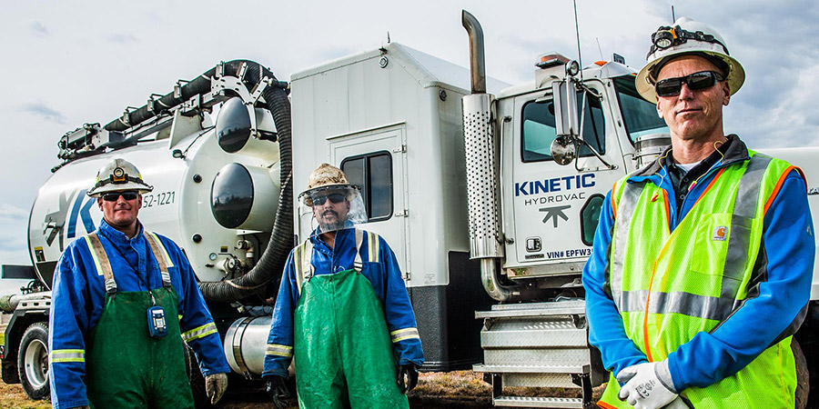 Kinetic Industry crew members in front of hydrovac truck